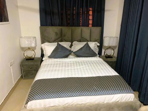 a bedroom with a large bed with two lamps at My5 Hotel in Kumasi