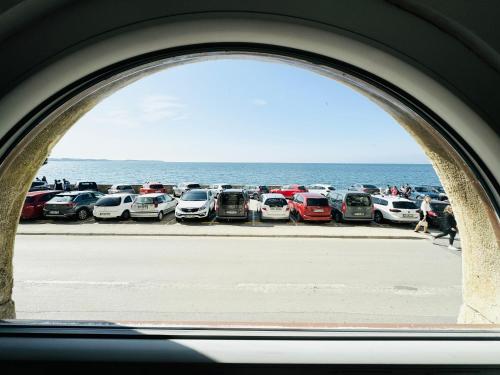 a view of a group of cars parked next to the ocean at APARTMA RIVIERA in Piran