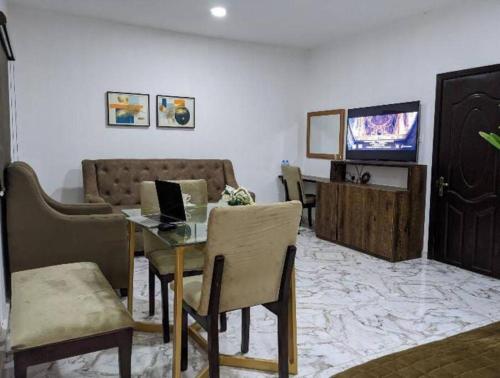 a living room with a table with a laptop on it at Cozy Studio room, Wi-Fi & Smart TV in Lagos