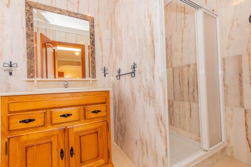 ein Badezimmer mit einem hölzernen Waschbecken und einem Spiegel in der Unterkunft Cubo's Villa Paraiso in Alhaurín el Grande