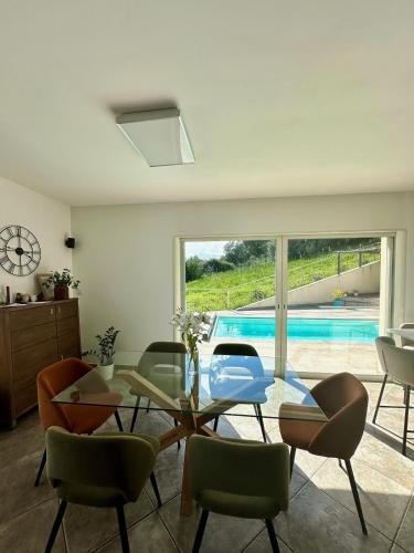 - un salon avec une table et des chaises en verre ainsi qu'une piscine dans l'établissement Villa Standing - Piscine et Vue Mer, à Alata