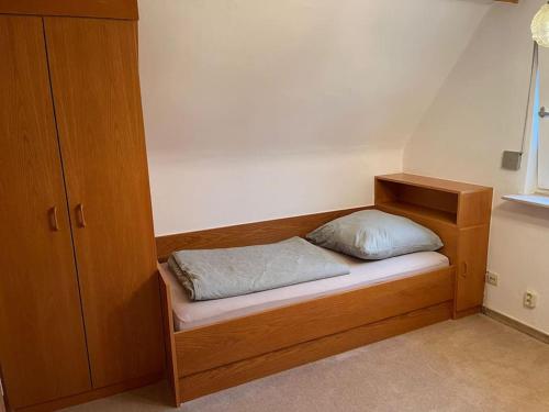 een houten bed met een kussen erop in een kamer bij Ferienhaus, Kassels bester Lage in Kassel