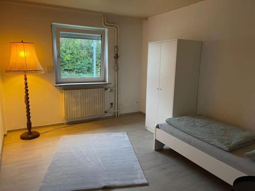 una habitación con una cama y una lámpara y una ventana en Ferienhaus, Kassels bester Lage, en Kassel