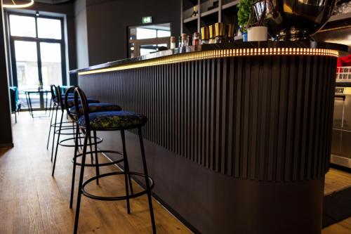 a bar with four stools sitting at a counter at N9 Hotels in Nürnberg
