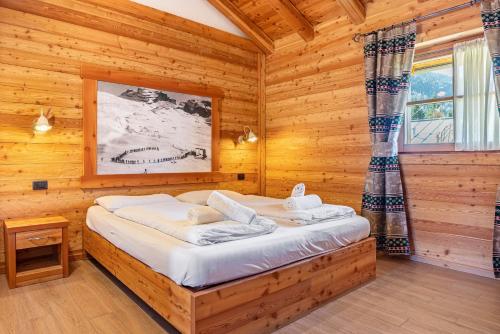 a bedroom with a bed in a log cabin at Chalet Camping Faè 3 in Madonna di Campiglio