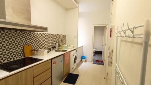 a kitchen with a sink and a counter top at Taragon Time Service Suite in Kuala Lumpur