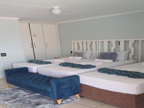 a room with four beds and a blue couch at TOP TOWN LODGE in Butterworth