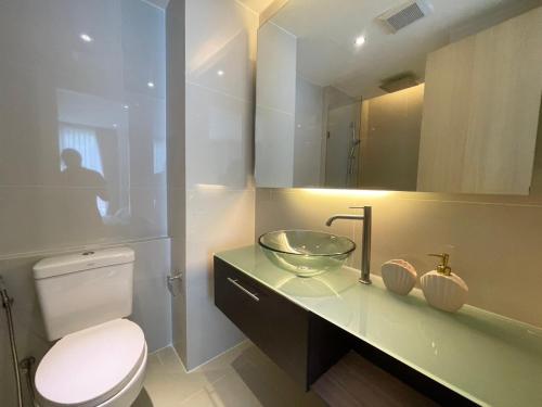 Un baño con lavabo, inodoro y espejo. en Grande Caribbean Resort Pattaya, en Pattaya South