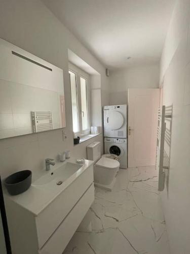 une salle de bain blanche avec des toilettes et un lavabo dans l'établissement t 3 place du village a 100 m du port de plaisance, à Saint-Florent