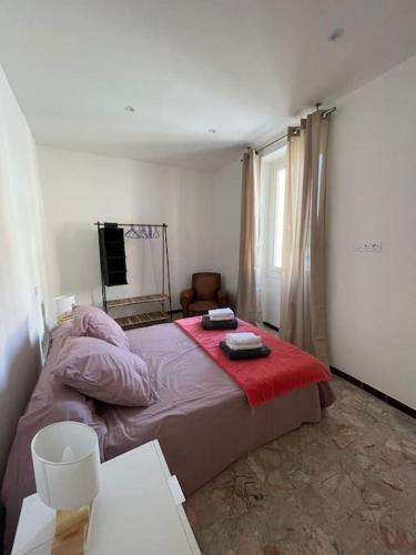 une chambre avec un lit avec une couverture rouge dans l'établissement t 3 place du village a 100 m du port de plaisance, à Saint-Florent