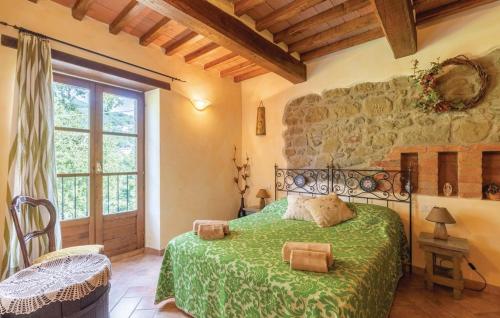 チッタ・ディ・カステッロにあるCasanova di Campersalleの緑のベッドと石の壁が備わるベッドルーム1室