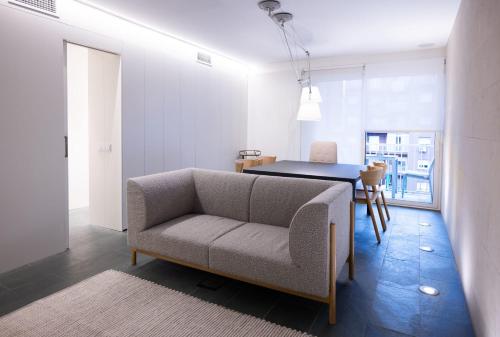 Ampersand - Bright 2-Bedroom Apartment في برشلونة: غرفة معيشة مع أريكة وطاولة