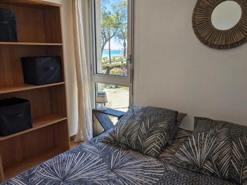 a bedroom with a bed and a large window at "Le palmier doré", cosy T3 front de mer in Sanary-sur-Mer