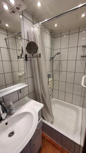 uma casa de banho com um chuveiro, um lavatório e uma banheira em Ferienwohnung Westerlicht - Apartment am Leuchtturm - De Torenhoeve em Nieuw-Haamstede