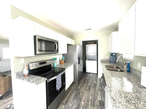 a kitchen with white cabinets and black appliances at Ocean Springs Cottage 2 Bedroom 2 Bath in Ocean Springs