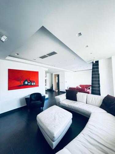 un soggiorno con divano bianco e sedia di St Julian Luxury Apartment Wish Malta a Paceville