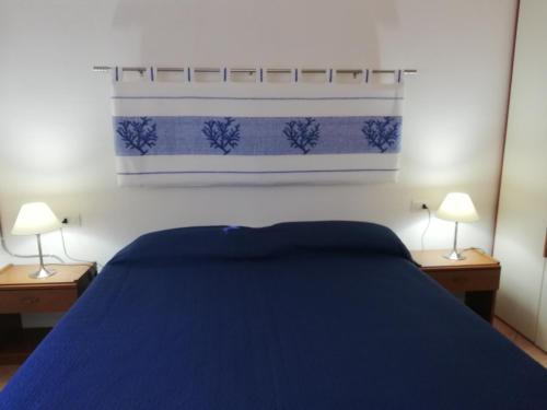 ein Schlafzimmer mit einem blauen Bett und zwei Lampen in der Unterkunft Vista Baia Blu in Budoni