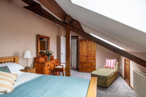um quarto com uma cama azul e uma cadeira em Fern Cottage at Hewish Mill em Bittadon