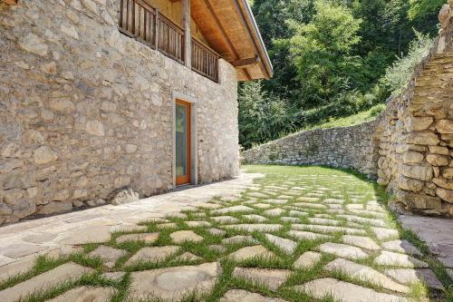a stone building with a walkway next to a stone wall at Casa al Mulino 2 in Tenno
