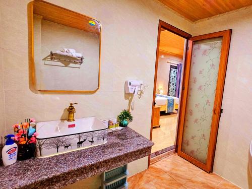 ein Bad mit einem Waschbecken und einem Spiegel in der Unterkunft Homestay Sala in Hồ Tràm