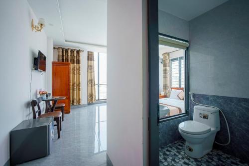 a bathroom with a toilet and a bed in a room at Phú Xuân Hotel in Quy Nhon