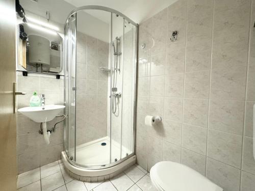 uma casa de banho com um chuveiro, um WC e um lavatório. em APARTMA PIRANESA em Piran