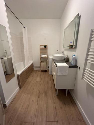 une salle de bain blanche avec un lavabo et un miroir dans l'établissement Le For’Home, à Arles