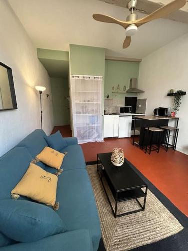 un salon avec un canapé bleu et une table dans l'établissement Le For’Home, à Arles