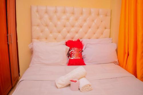 a red teddy bear sitting on top of a bed at KIsumu Cozy One bedroom Apartment in Kisumu
