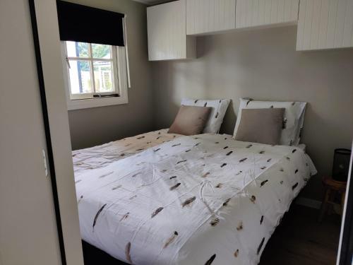 a bedroom with a large bed with white sheets and pillows at Park De Driesprong in Nieuwveen