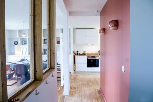 une cuisine aux murs roses et une table avec des chaises dans l'établissement Ker Seasea/vue mer/wifi, à Crozon