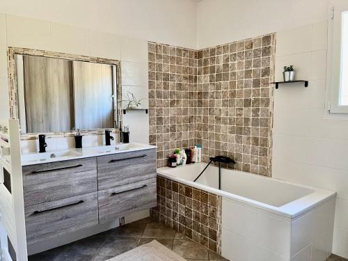 une salle de bain avec une baignoire, un lavabo et un miroir dans l'établissement Villa Standing - Piscine et Vue Mer, à Alata