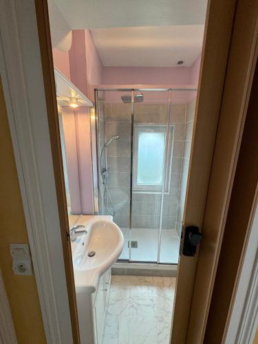 une salle de bain avec un lavabo et une douche dans l'établissement Le Martin Pêcheur, à Port-en-Bessin-Huppain