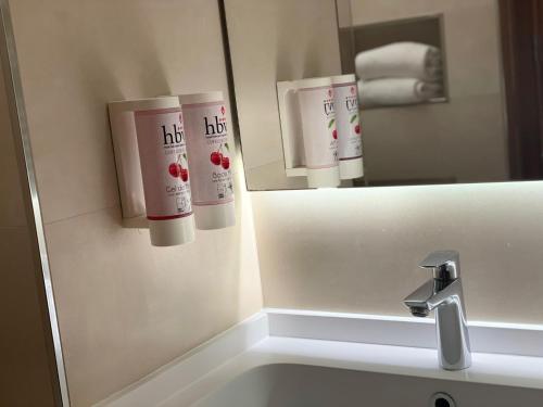 a bathroom with a mirror and a sink at Hotel Balneario Valle del Jerte in Valdastillas