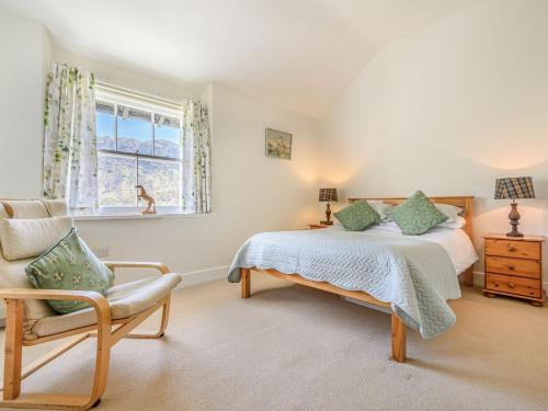 a bedroom with a bed and a chair and a window at 3 Bed in Borrowdale SZ234 in Rosthwaite