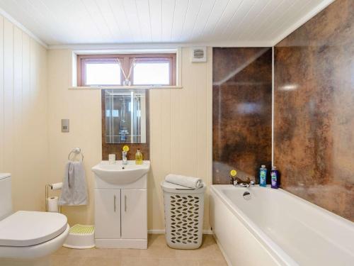a bathroom with a tub and a toilet and a sink at 2 Bed in Sowerby Bridge 90887 in Sowerby Bridge