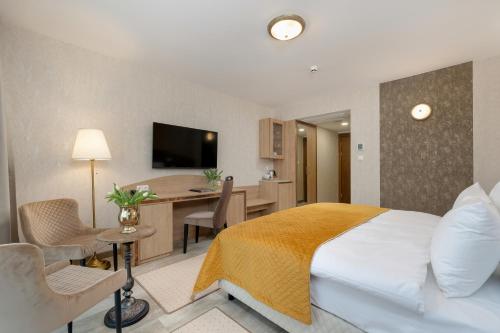 a hotel room with a bed and a desk at Juvena Hotel Wellness & SPA Adults Only 12 plus in Międzywodzie