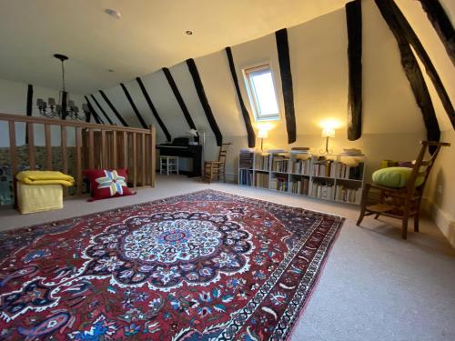 a living room with a large rug on the floor at Gîte Maison Maitri in Forgès