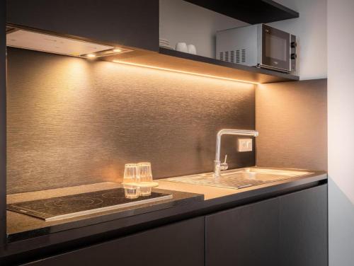 a kitchen with a sink and a counter top at Hotel Jamingo in Antwerp