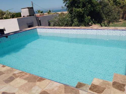 ein großer Pool mit blauem Wasser in der Unterkunft Maisonnette vue mer en pleine campagne. Originale. in El Jadida