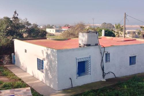ein weißes Haus mit rotem Dach in der Unterkunft Maisonnette vue mer en pleine campagne. Originale. in El Jadida