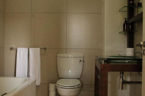 uma casa de banho com um WC branco e um lavatório. em Jackal Creek Golf Estate em Roodepoort