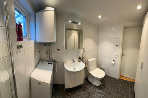 uma casa de banho branca com um lavatório e um WC em Kojan em Vaxholm