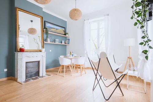 - un salon avec une cheminée, une table et des chaises dans l'établissement F2 un dimanche à Vichy Villa Marie Celine, à Vichy