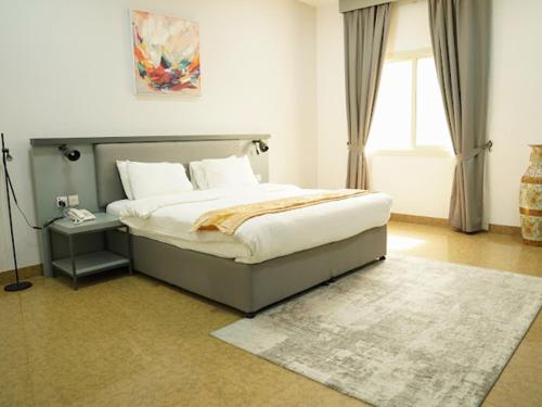 a bedroom with a large bed and a rug at Saḟeer international alkhuwair in Muscat