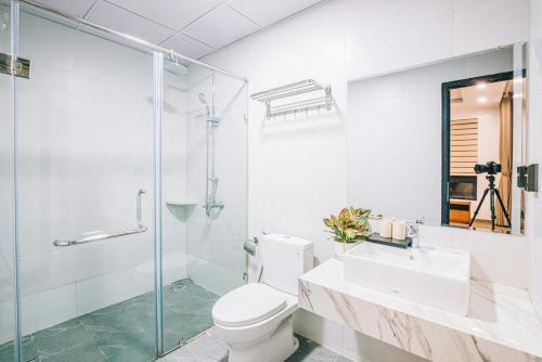 a bathroom with a toilet and a sink and a shower at Sea Villa - FLC Sam Son in Sầm Sơn