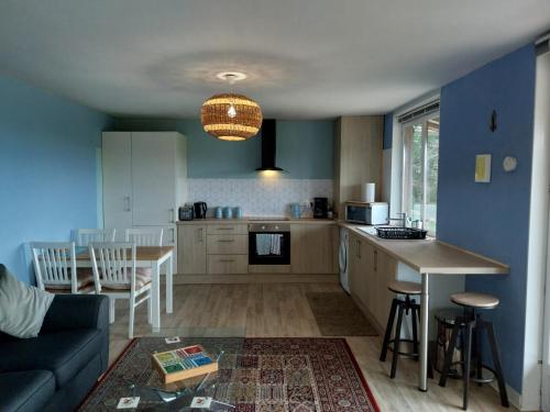 une cuisine et un salon avec un canapé et une table dans l'établissement La Petite Maison à Vieillecour, à Saint-Pierre-de-Frugie