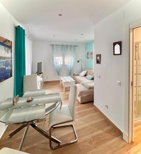 a living room with a glass table and a couch at Casa San Miguel in Estepona