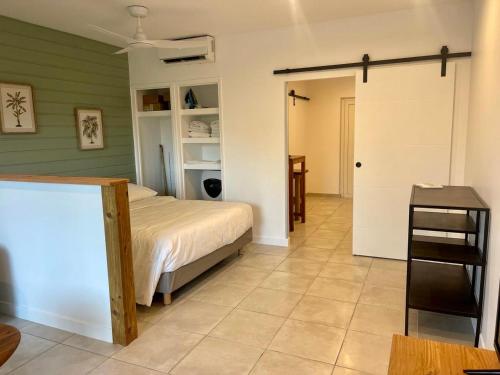 a bedroom with a bed and a sliding door at La Tanière de Saint-Martin in Orient Bay