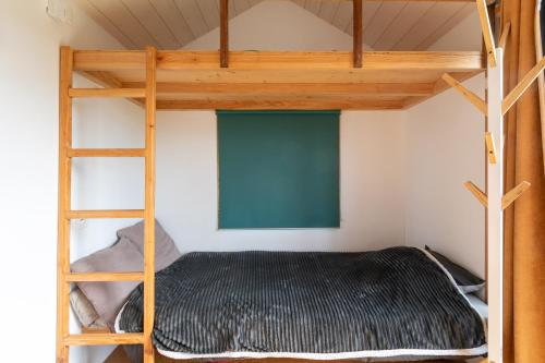 Très Jolie Tiny House Tout Confort في Prat: غرفة نوم بسريرين بطابقين وسلم